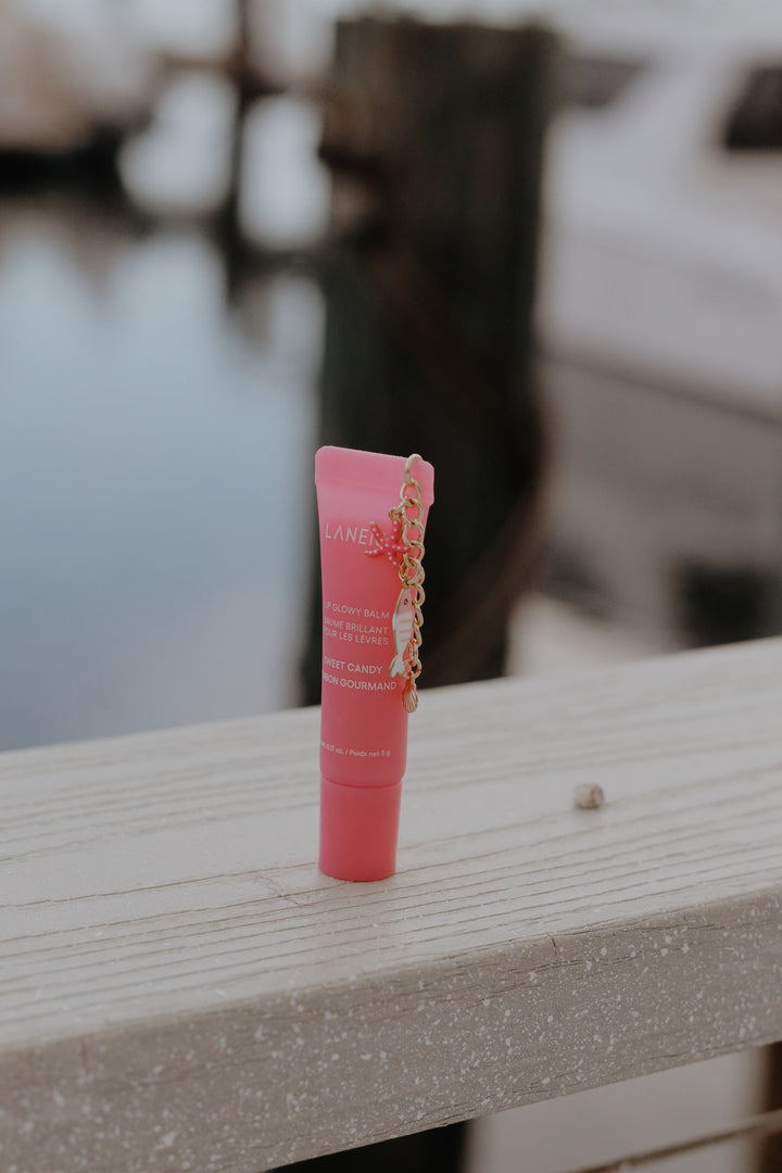 Pink lip balm tube on a wooden surface with a blurred background