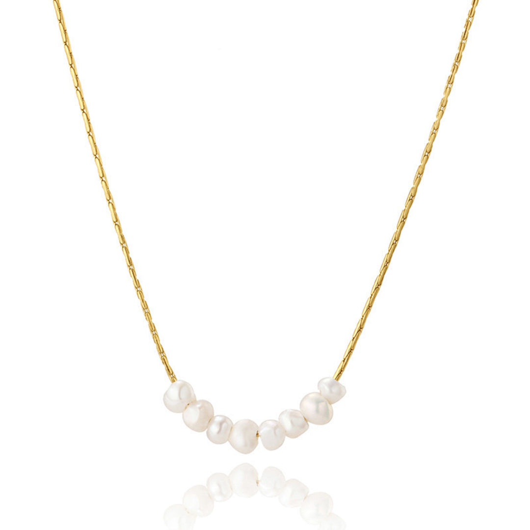 Gold necklace with white pearls on a white background