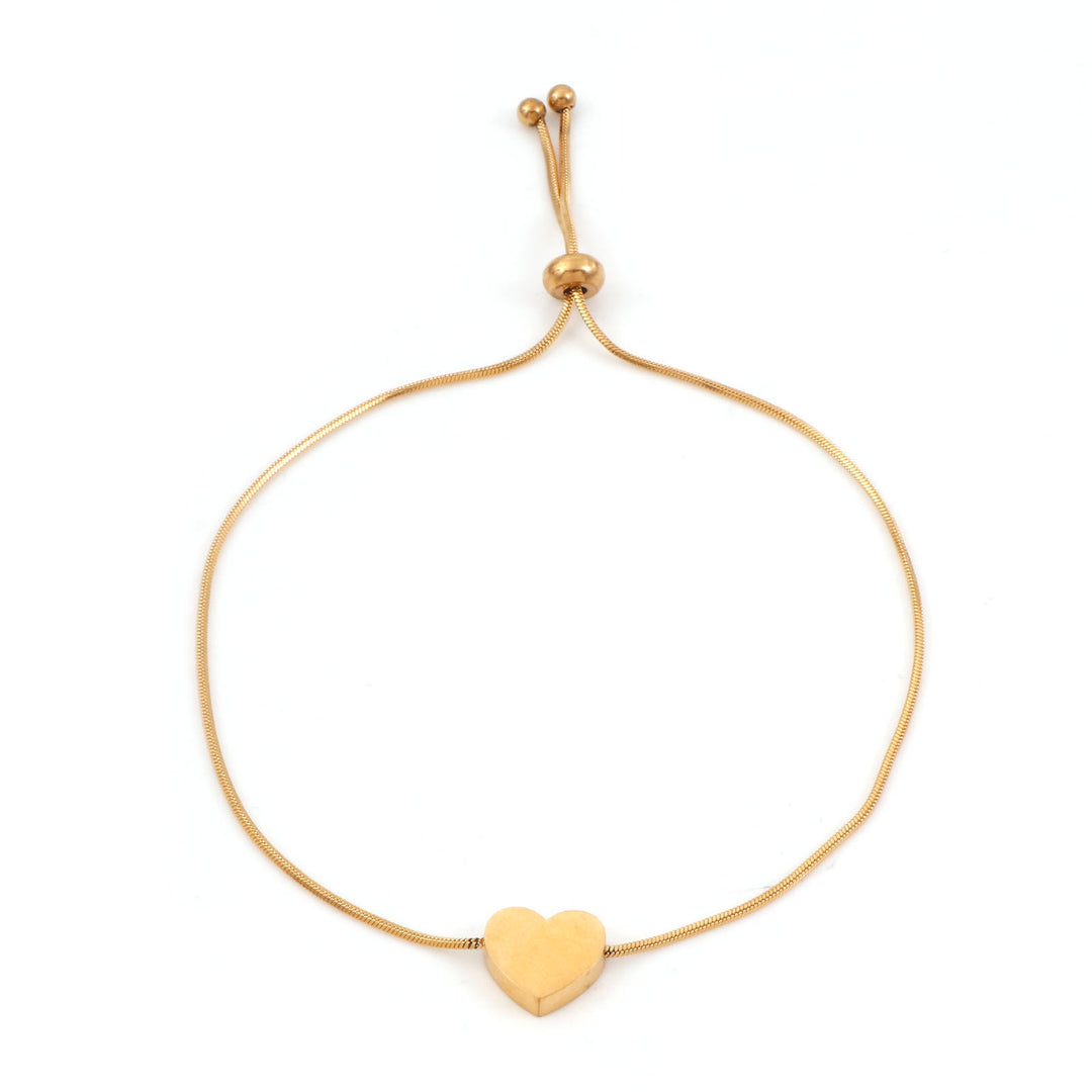 Gold bracelet with a heart charm on a white background